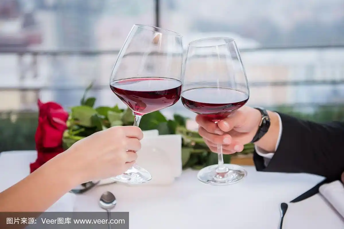 情侣在餐厅庆祝情人节的时候碰杯喝红酒的镜头
