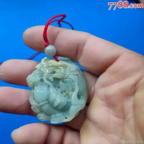 一个雕刻鲤鱼跳龙门和荷花莲蓬图案的翡翠玉挂件