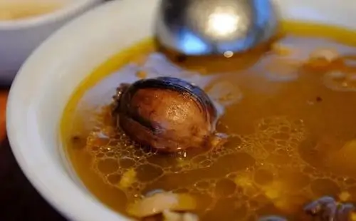 锅中,民警捞出一个沉在锅底的料包,里面竟裹着铁钉和两颗完整的罂粟果