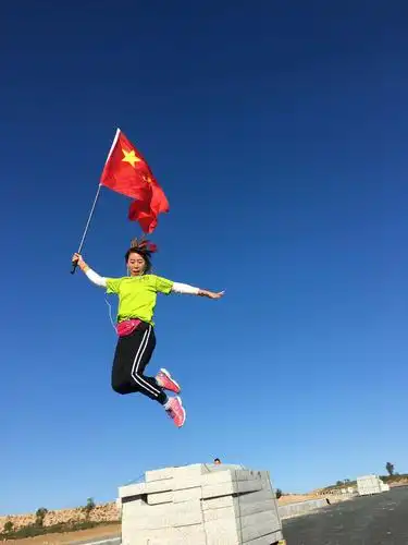 这姿势漂亮极了,五星红旗飘扬在蔚蓝的天空.
